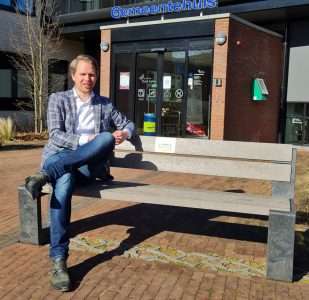 Bart Porskamp op bankje voor het gemeentehuis (Terugwinnaars)