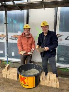 Locatiemanager Anita Rietman en wethouder Arjen van Gijssel leggen de eerste steen van Het Berkelhuis in Eibergen