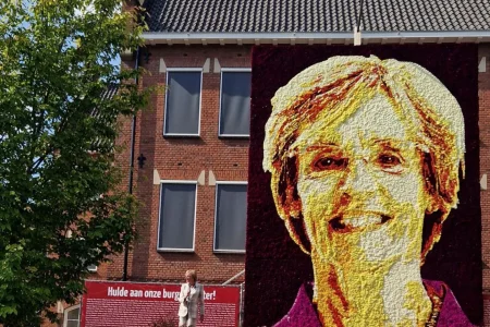 Metershoog dahliaportret van burgemeester Annette Bronsvoort, onthuld bij het gemeentehuis in Lichtenvoorde. Het kunstwerk is gemaakt door de corsogemeenschap met 25.000 dahlia’s.