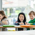 Teacher Helping Young Children During Tech Workshop